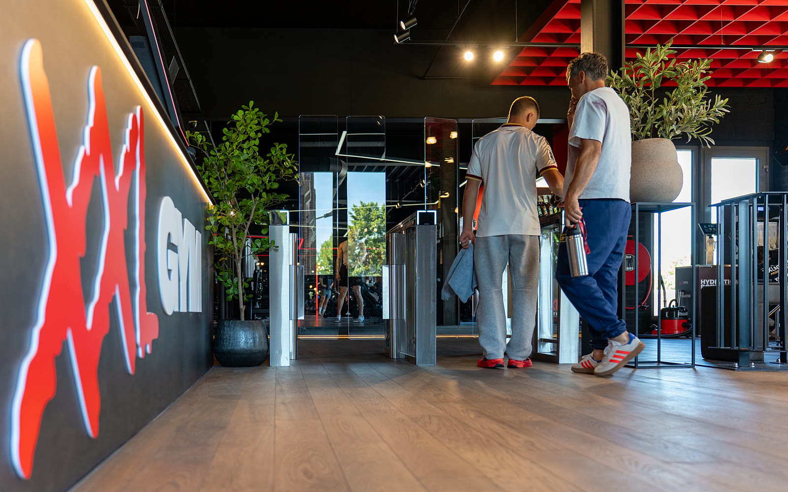 Leden lopen door de speedgates bij de entree van XXL GYM